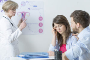 doctor and couple dealing with infertility problems
