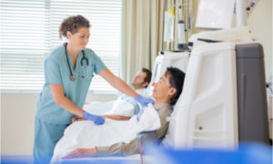 The nurse assists the patient with his dialysis.